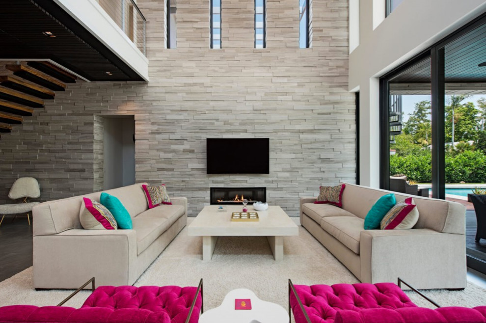 This is an example of a large contemporary open concept living room in Miami with white walls, a ribbon fireplace and a wall-mounted tv.