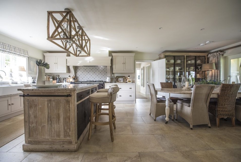 Photo of a large country eat-in kitchen in Other with beige cabinets, multi-coloured splashback, ceramic splashback, with island, beige floor, a farmhouse sink and shaker cabinets.