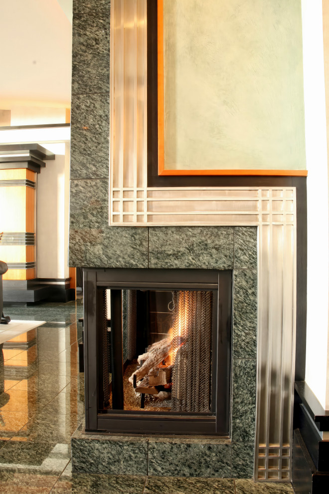 This is an example of a modern living room in Minneapolis with a corner fireplace and a metal fireplace surround.
