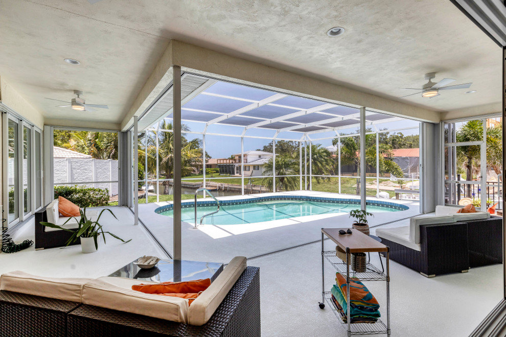 This is an example of a mid-sized beach style backyard kidney-shaped pool in Tampa.