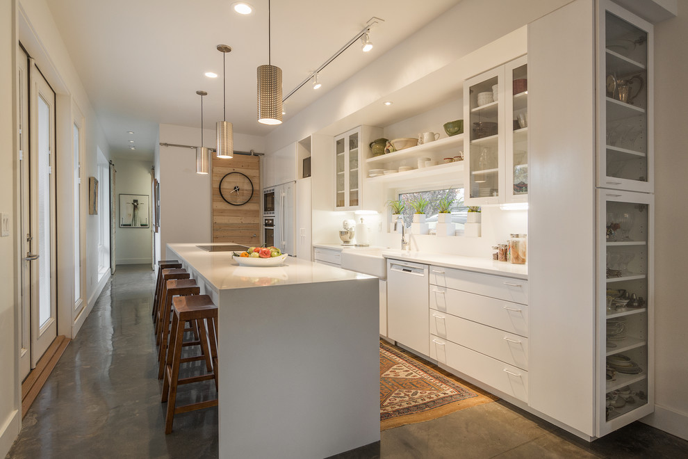 Inspiration for a contemporary galley kitchen in Salt Lake City with a farmhouse sink, flat-panel cabinets, white cabinets, white appliances and with island.