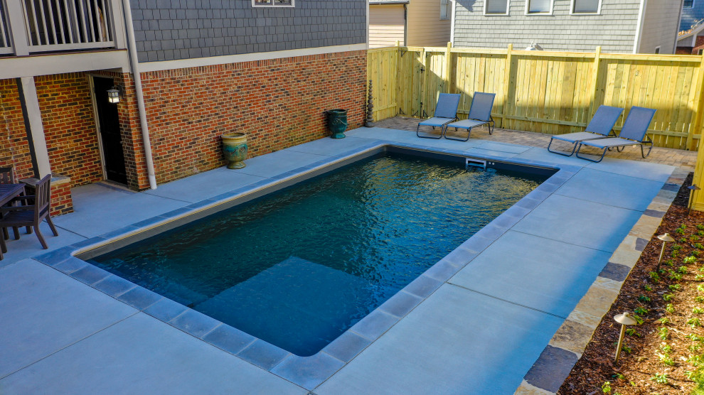 Пример оригинального дизайна: маленький прямоугольный бассейн на заднем дворе с покрытием из бетонных плит для на участке и в саду