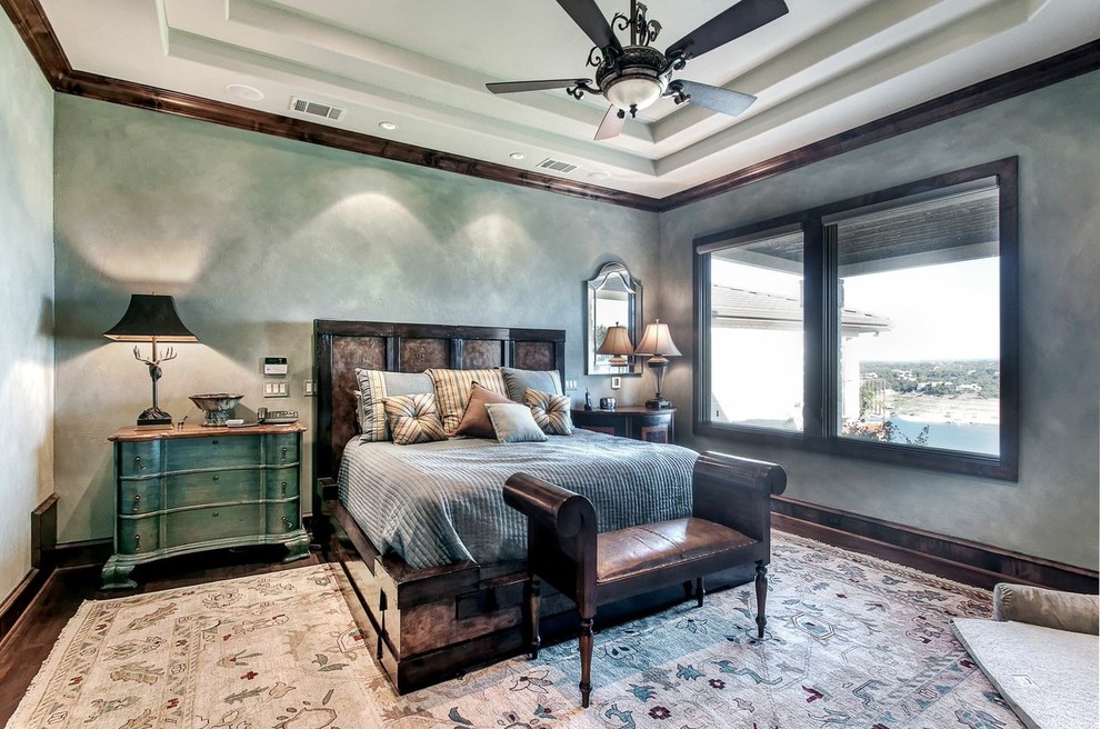 Photo of a large mediterranean master bedroom in Austin with green walls, dark hardwood floors and no fireplace.