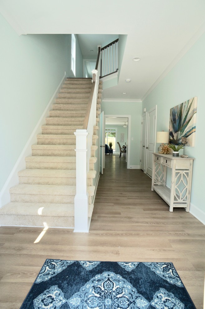 Design ideas for a mid-sized beach style foyer in Other with blue walls, light hardwood floors, a single front door, a yellow front door and brown floor.