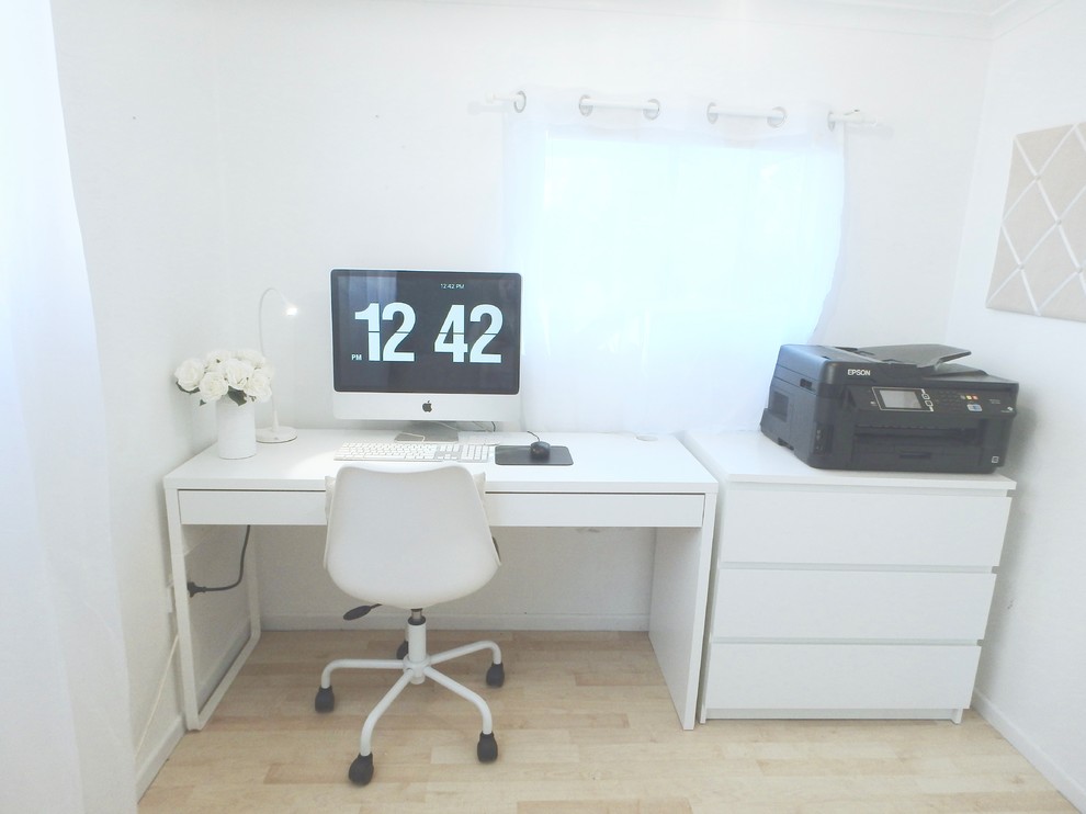 This is an example of a small contemporary study room in Brisbane with white walls, laminate floors, no fireplace, a freestanding desk and beige floor.