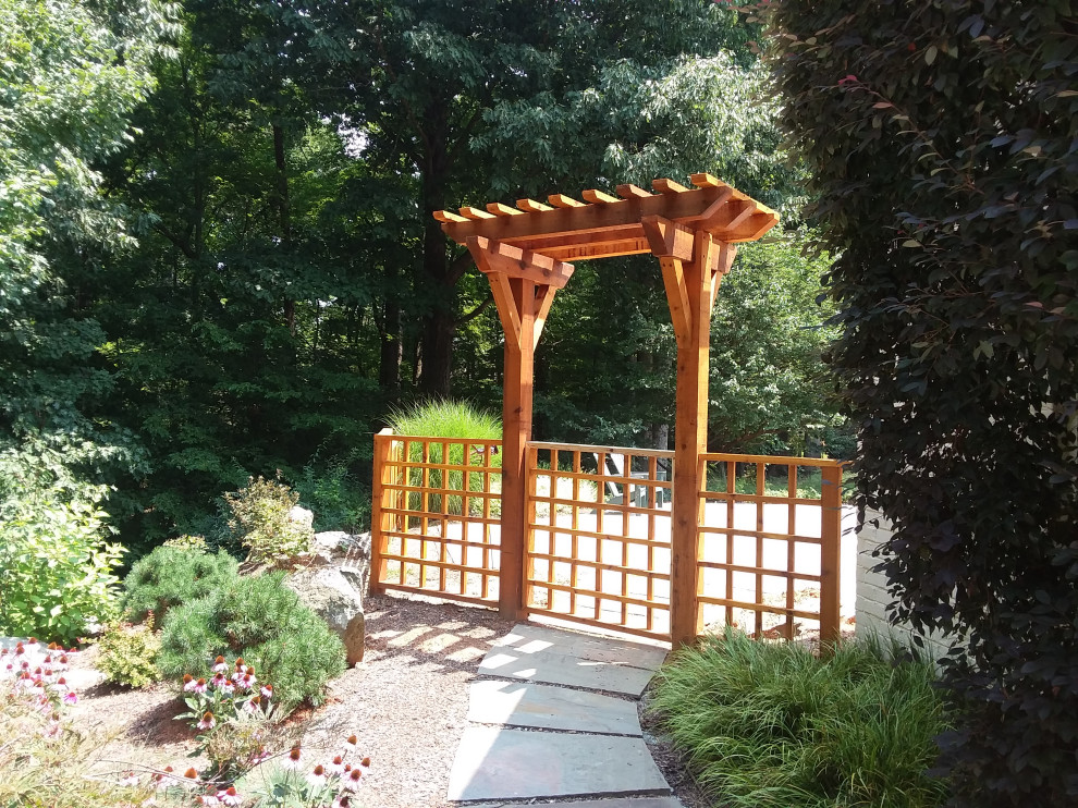 Inspiration for an expansive traditional backyard and ground level deck in Other with a pergola.