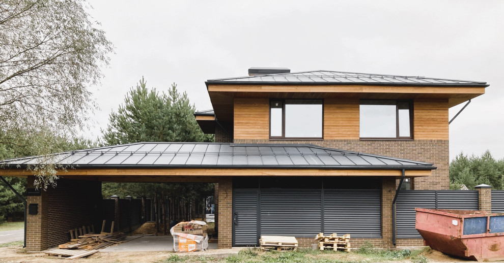 Idée de décoration pour une façade de maison marron design en brique et bardage à clin de taille moyenne et à un étage avec un toit à quatre pans, un toit en métal et un toit gris.
