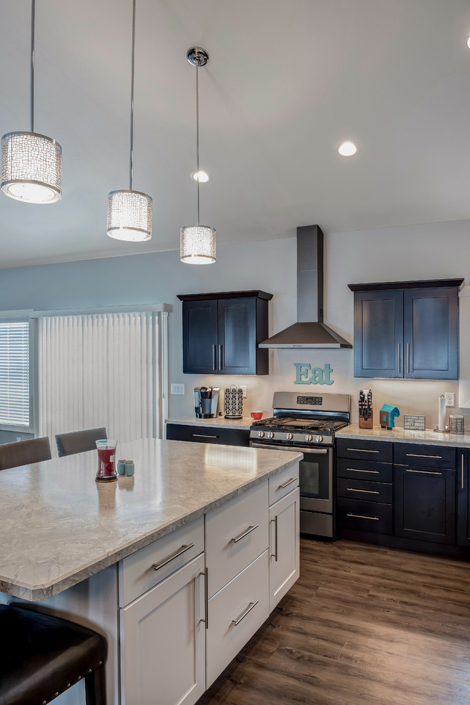 Open concept kitchen - large transitional l-shaped medium tone wood floor open concept kitchen idea with a double-bowl sink, shaker cabinets, dark wood cabinets, quartzite countertops, stainless steel appliances and an island