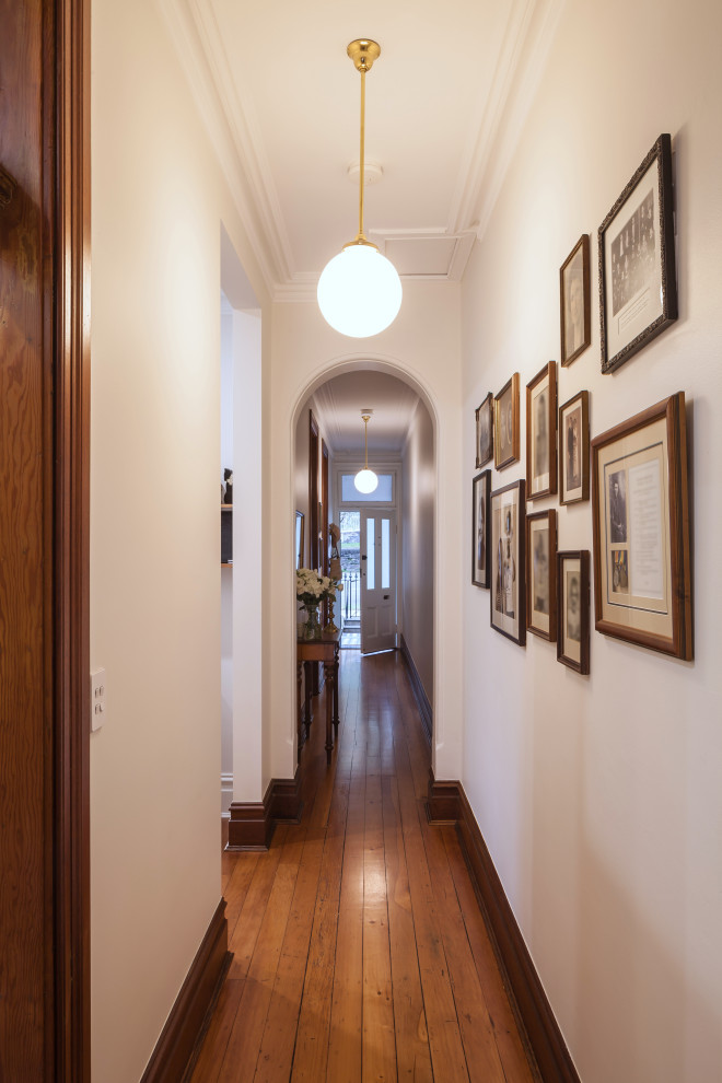 Inspiration for a small traditional hallway in Sydney with white walls, medium hardwood floors and brown floor.