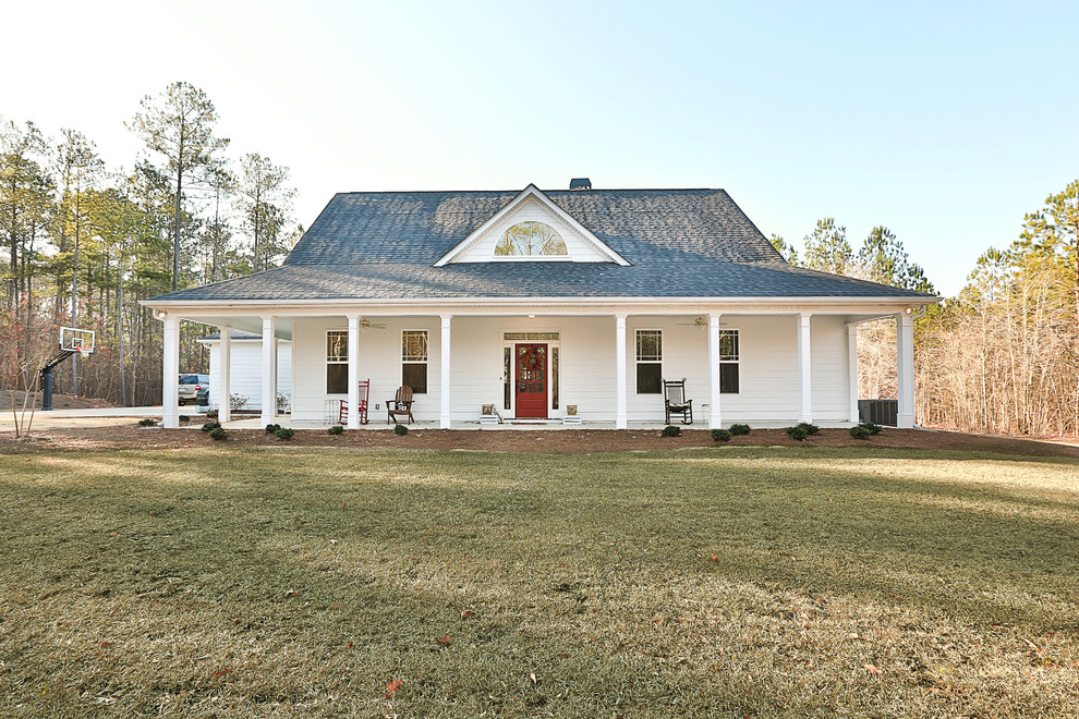 This is an example of a mid-sized country two-storey white house exterior in Atlanta with concrete fiberboard siding, a gable roof and a shingle roof.