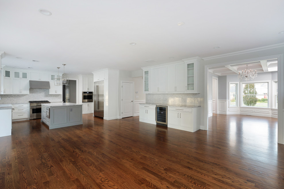 Eat-in kitchen - large transitional u-shaped medium tone wood floor eat-in kitchen idea with a farmhouse sink, shaker cabinets, white cabinets, stainless steel appliances and an island