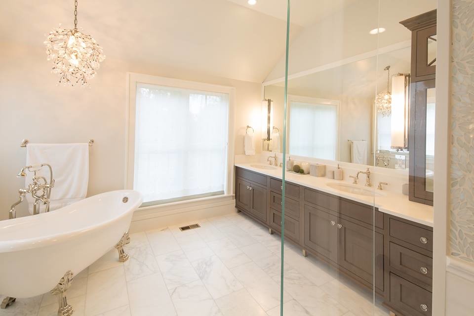 Design ideas for a large traditional master bathroom in Boise with recessed-panel cabinets, brown cabinets, a claw-foot tub, an open shower, beige walls, marble floors, an undermount sink, engineered quartz benchtops, multi-coloured floor, a hinged shower door and white benchtops.