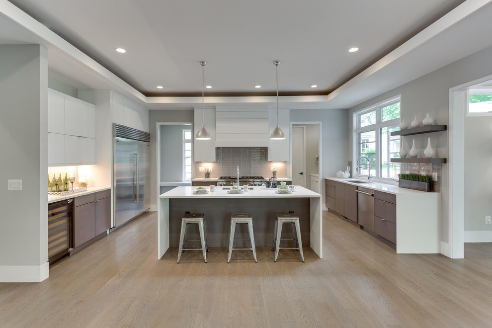 Mid-sized transitional u-shaped open plan kitchen in Other with an undermount sink, flat-panel cabinets, medium wood cabinets, solid surface benchtops, stainless steel appliances, light hardwood floors, with island and beige floor.