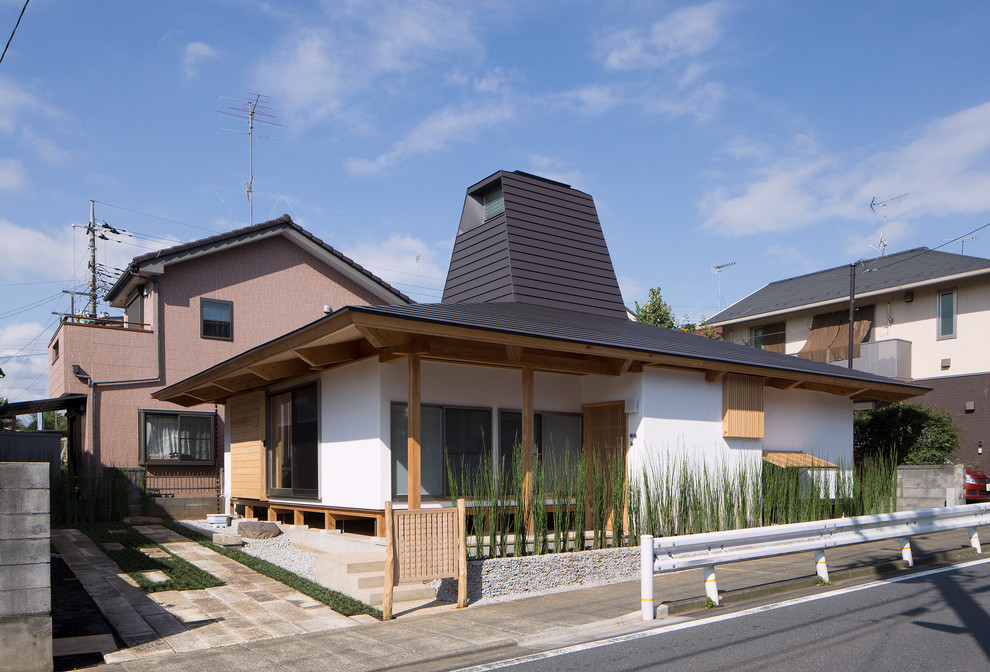 This is an example of a mid-sized modern one-storey stucco white house exterior in Tokyo Suburbs with a hip roof and a metal roof.