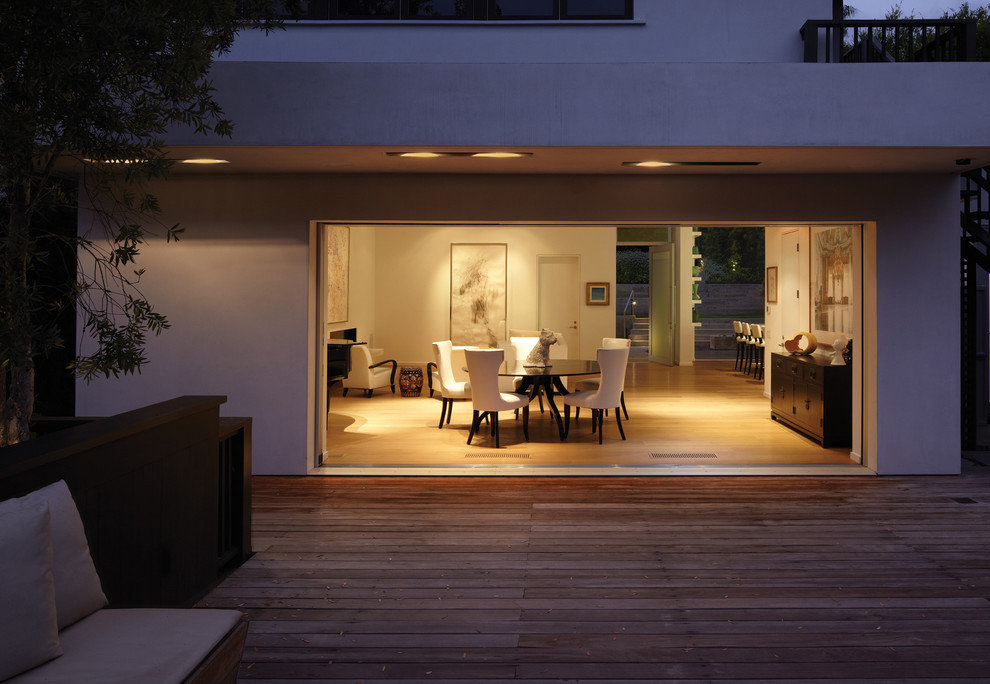Design ideas for a mid-sized modern backyard deck in Los Angeles with a roof extension.