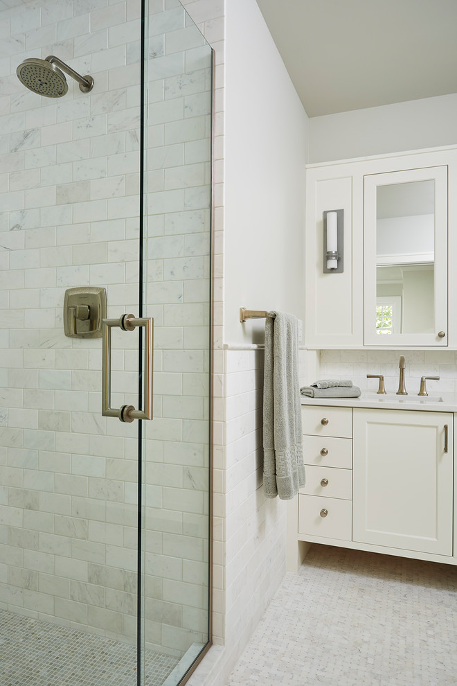 Photo of a mid-sized traditional master bathroom in Minneapolis with recessed-panel cabinets, white cabinets, an alcove shower, a one-piece toilet, white tile, subway tile, white walls, ceramic floors, an undermount sink, quartzite benchtops, white floor and a hinged shower door.