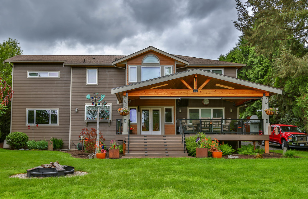 Example of a large mountain style two-story wood brown deck design in Seattle with a hip roof and a shingle roof