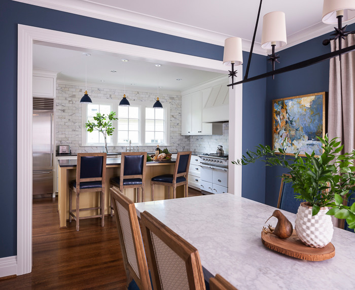 Transitional dark wood floor kitchen photo in Seattle with an undermount sink, shaker cabinets, white cabinets, quartz countertops, white backsplash, subway tile backsplash, stainless steel appliances and an island