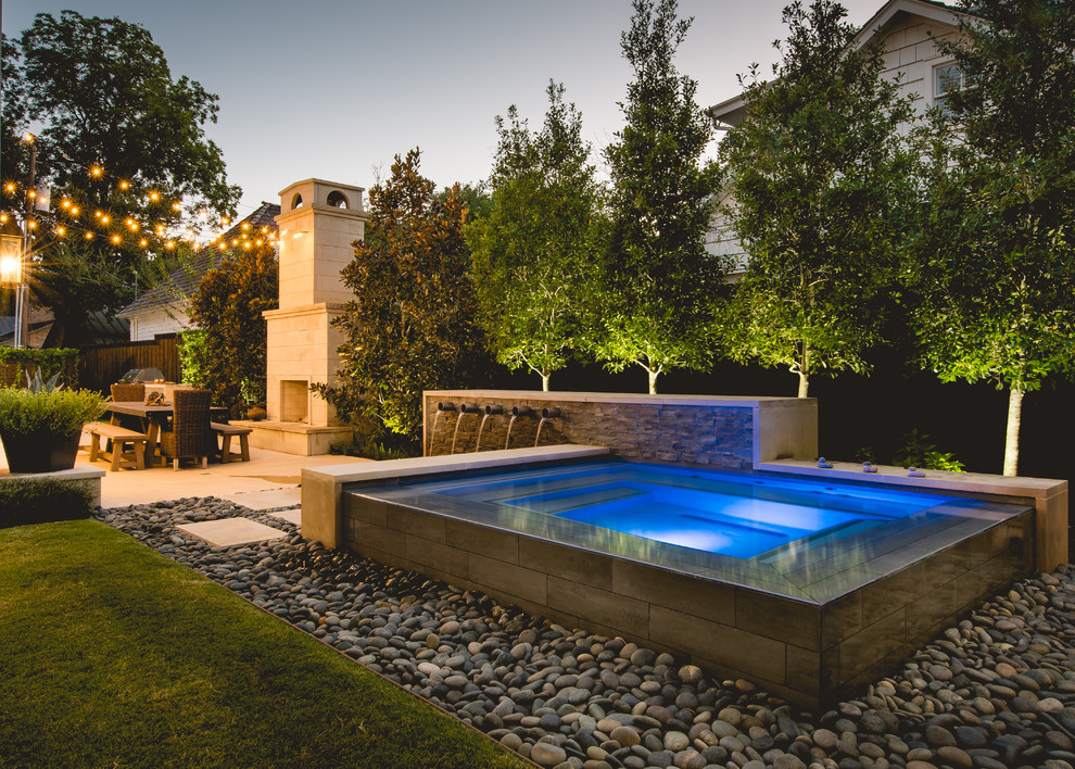 This is an example of a small contemporary backyard rectangular infinity pool in Dallas with a hot tub.