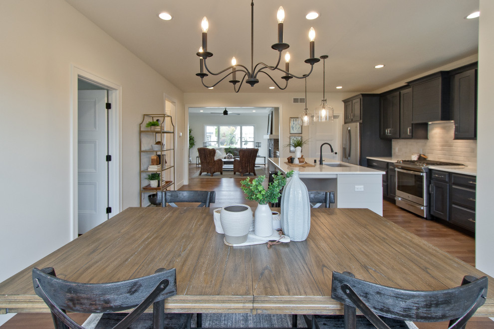 Transitional light wood floor and brown floor kitchen/dining room combo photo with white walls