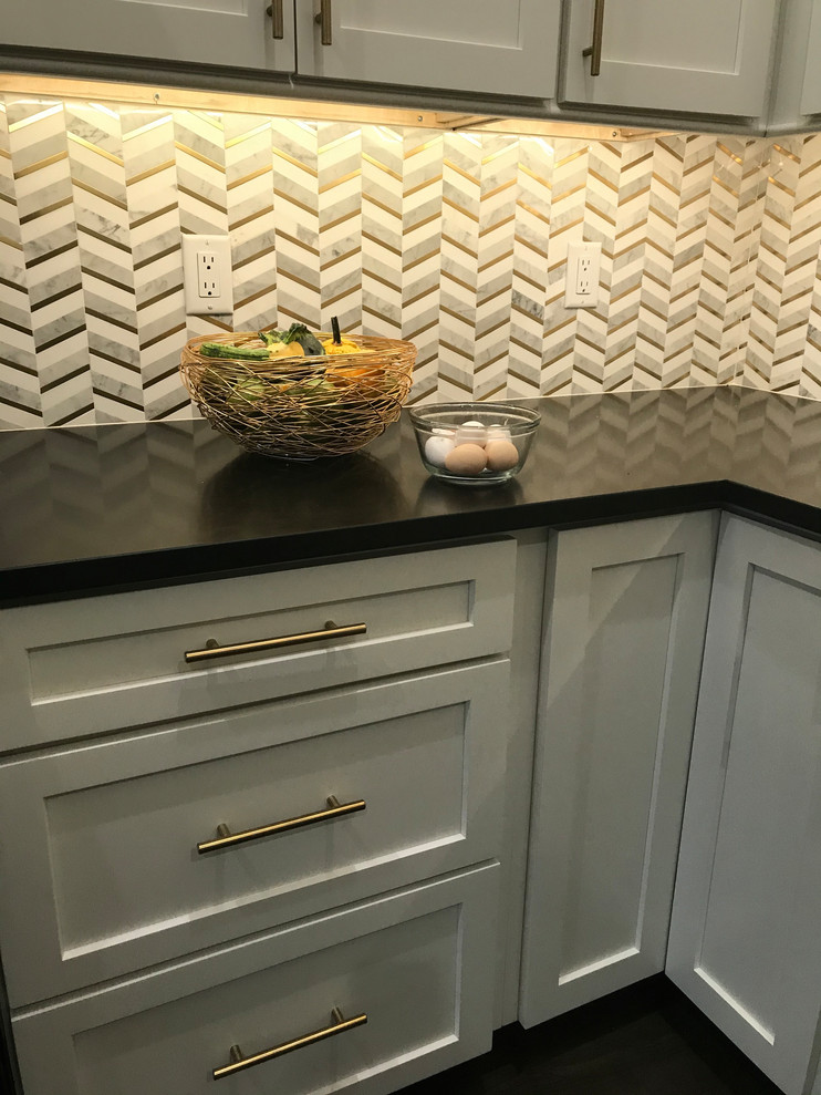Huge transitional l-shaped vinyl floor and brown floor open concept kitchen photo in Baltimore with an undermount sink, shaker cabinets, white cabinets, quartz countertops, white backsplash, marble backsplash, stainless steel appliances, an island and multicolored countertops