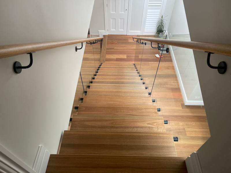 Inspiration pour un escalier sans contremarche flottant minimaliste de taille moyenne avec des marches en bois et un garde-corps en bois.