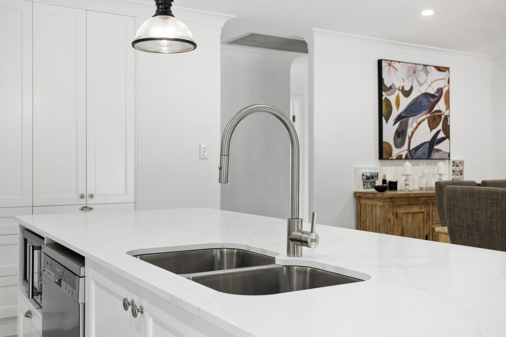 Mid-sized transitional galley kitchen pantry in Gold Coast - Tweed with an undermount sink, shaker cabinets, white cabinets, quartz benchtops, orange splashback, mosaic tile splashback, stainless steel appliances, porcelain floors, with island, white floor and yellow benchtop.