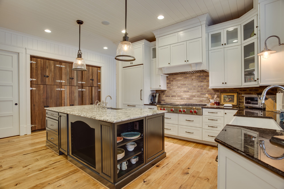 This is an example of a large country u-shaped kitchen in DC Metro with a farmhouse sink, granite benchtops, stainless steel appliances, medium hardwood floors and with island.