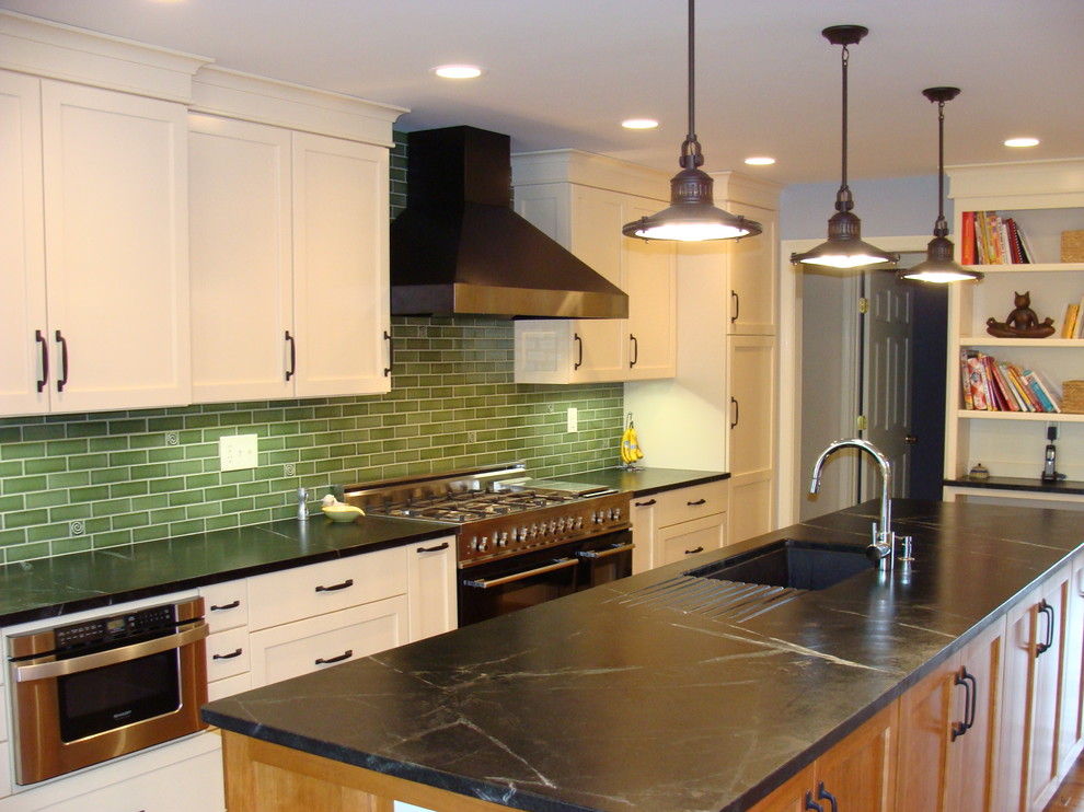 Photo of an eclectic galley eat-in kitchen in Louisville with a single-bowl sink, soapstone benchtops, green splashback, subway tile splashback, shaker cabinets, white cabinets and stainless steel appliances.