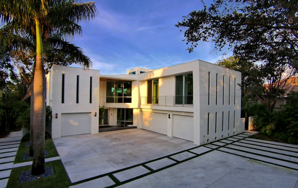 This is an example of an expansive modern front yard full sun driveway for winter in Tampa with concrete pavers.