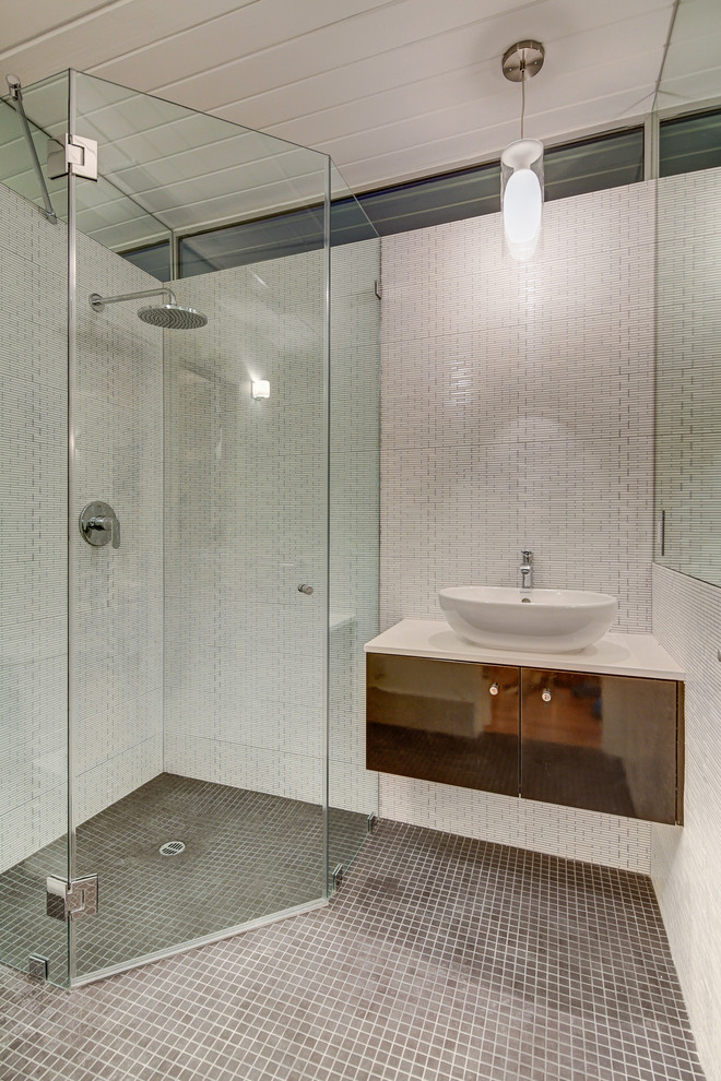 Photo of a midcentury bathroom in Los Angeles with a vessel sink, flat-panel cabinets, brown cabinets, a corner shower and white tile.