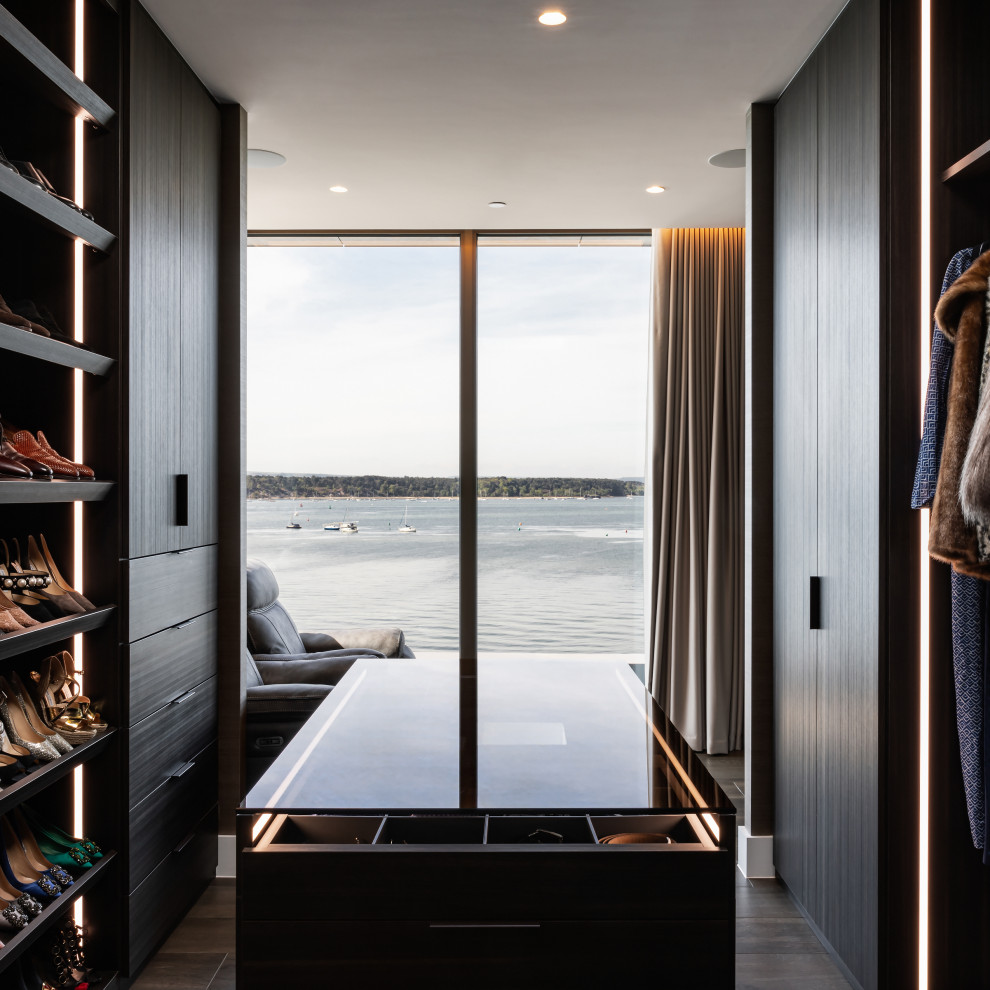 Идея дизайна: гардеробная комната среднего размера, унисекс в современном стиле с открытыми фасадами и темными деревянными фасадами