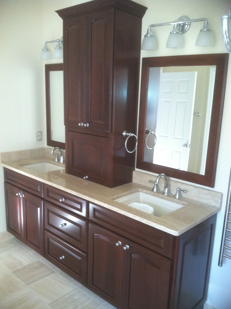 This is an example of a mid-sized traditional master bathroom in DC Metro with raised-panel cabinets, medium wood cabinets, a drop-in tub, an alcove shower, a one-piece toilet, beige tile, travertine, green walls, travertine floors, an undermount sink, terrazzo benchtops, beige floor, a hinged shower door and beige benchtops.