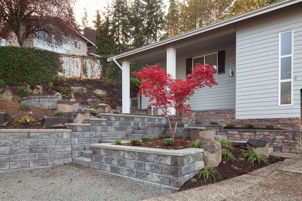 Large traditional front yard partial sun formal garden in Seattle with a retaining wall and mulch.