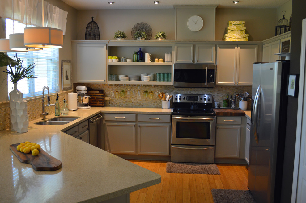 Mid-sized arts and crafts u-shaped open plan kitchen in Orlando with a double-bowl sink, beige cabinets, beige splashback, matchstick tile splashback, stainless steel appliances, medium hardwood floors, no island, recessed-panel cabinets and terrazzo benchtops.