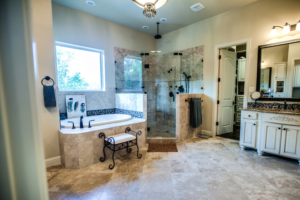 This is an example of a mid-sized traditional master bathroom in Dallas with an undermount sink, raised-panel cabinets, beige cabinets, granite benchtops, a drop-in tub, a one-piece toilet, beige tile, terra-cotta tile, beige walls, travertine floors and a corner shower.
