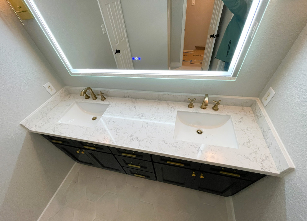 Photo of a mid-sized contemporary bathroom in Houston with blue cabinets, a shower/bathtub combo, gray tile, porcelain tile, grey walls, porcelain floors, engineered quartz benchtops, grey floor, white benchtops and a double vanity.