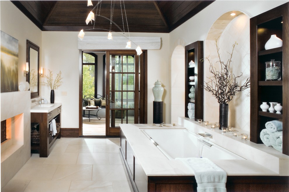 Design ideas for a transitional master bathroom in Chicago with open cabinets, dark wood cabinets, an undermount tub, beige walls, an undermount sink, limestone floors and beige floor.