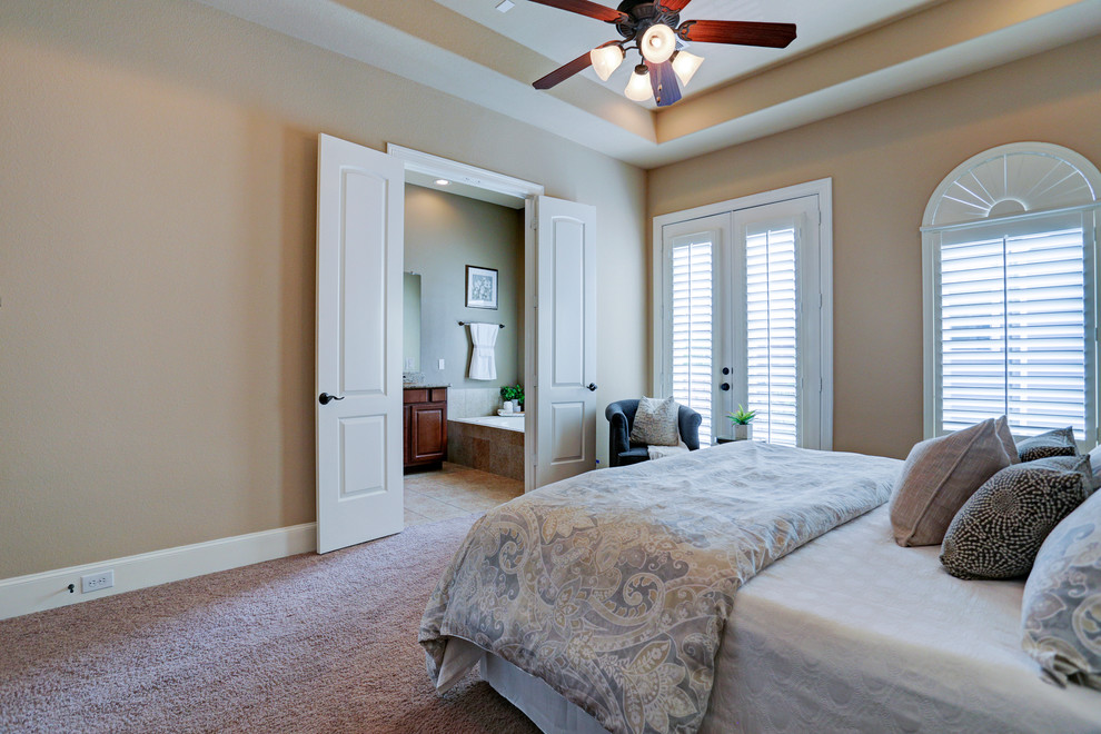 Small transitional master bedroom in Houston with beige walls, a wood fireplace surround and carpet.