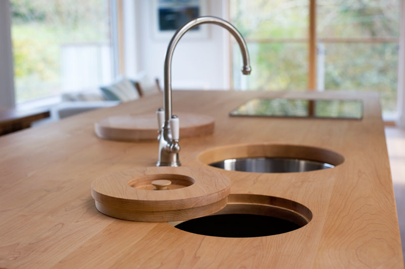 Aménagement d'une cuisine américaine bord de mer avec un évier encastré, des portes de placard bleues, un plan de travail en bois et îlot.