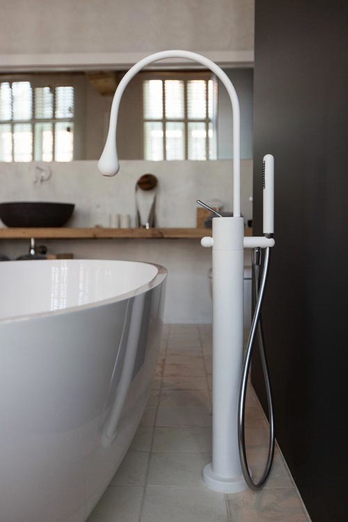 Example of a small eclectic master gray tile and ceramic tile freestanding bathtub design in Chicago with a vessel sink, open cabinets, light wood cabinets, wood countertops and a wall-mount toilet