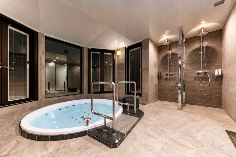 モダンスタイルのおしゃれな浴室 (ドロップイン型浴槽、ベージュの壁、ベージュの床、折り上げ天井) の写真