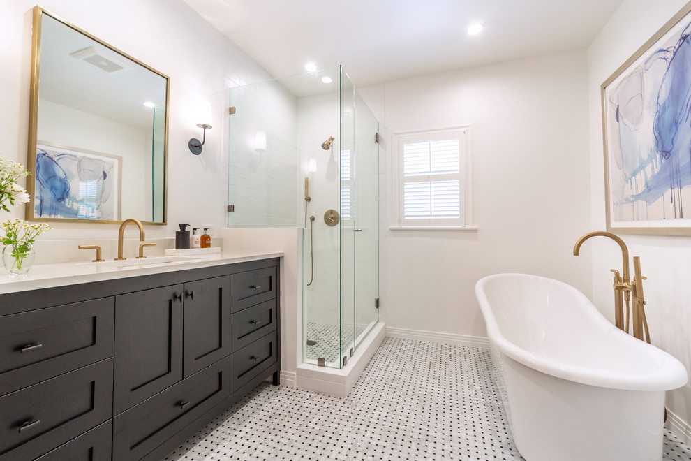 This is an example of a transitional master bathroom in Los Angeles with black cabinets, a freestanding tub, a corner shower, white walls, mosaic tile floors, an undermount sink, grey floor, a hinged shower door and shaker cabinets.