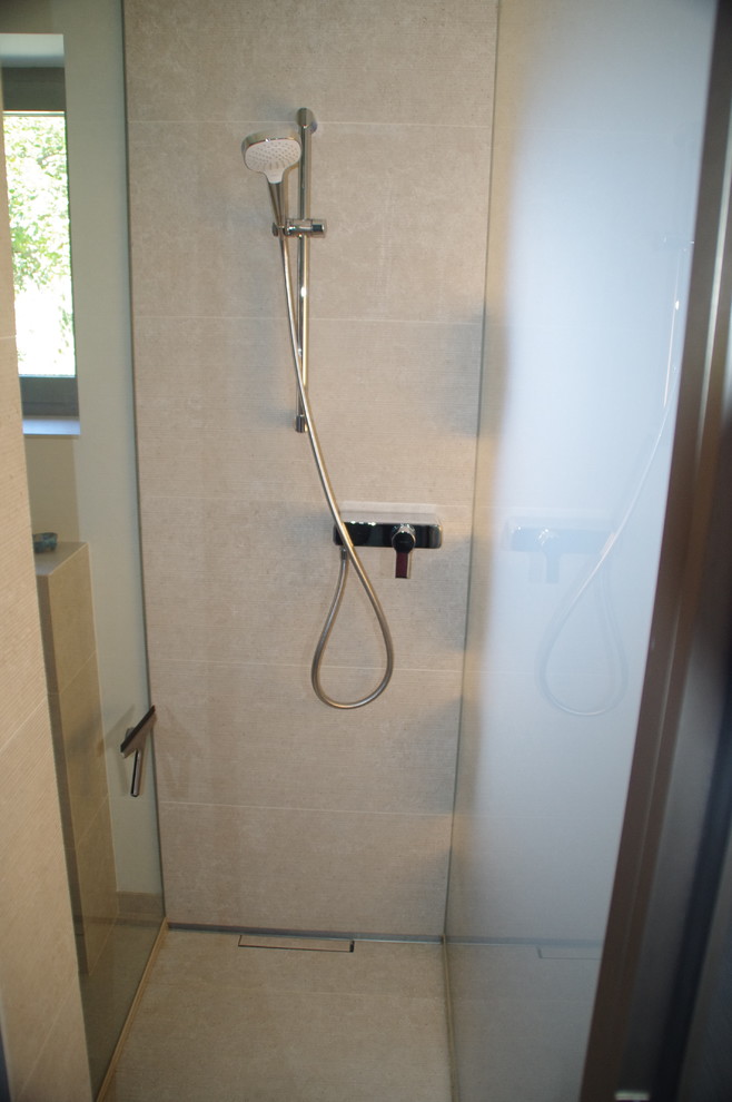 Modernes Duschbad mit bodengleicher Dusche, Wandtoilette, Aufsatzwaschbecken und offener Dusche in Berlin