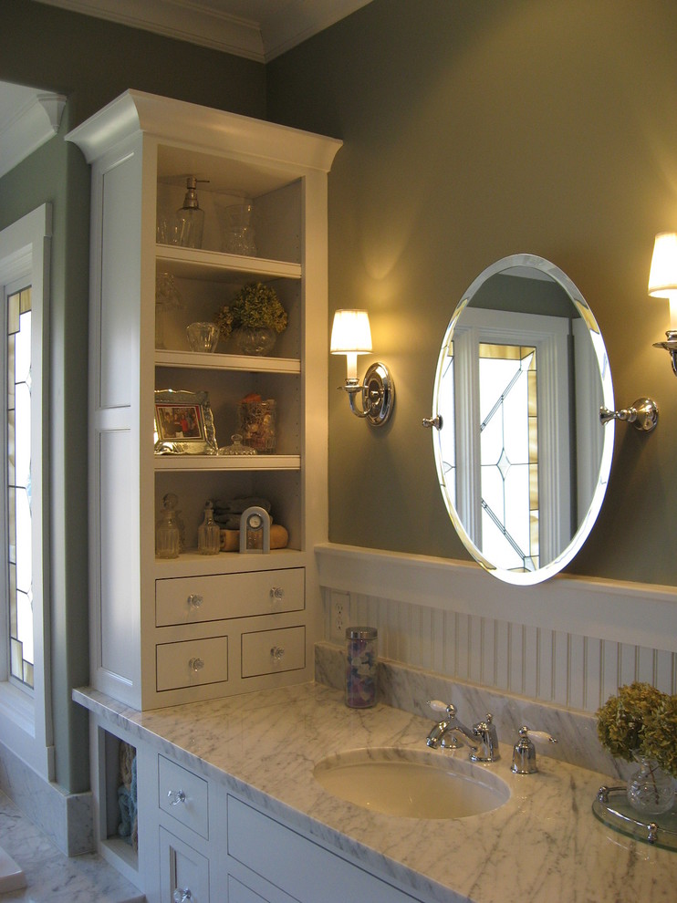Example of a transitional white tile and stone slab drop-in bathtub design with recessed-panel cabinets, white cabinets and marble countertops