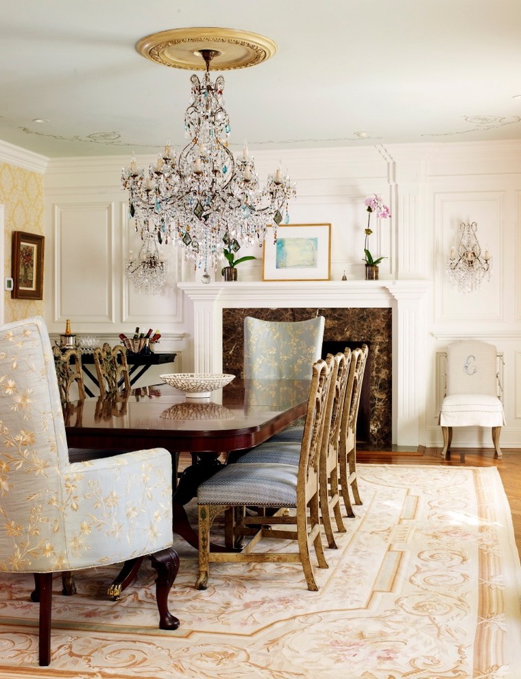 Traditional dining room in New York with white walls, medium hardwood floors and a standard fireplace.