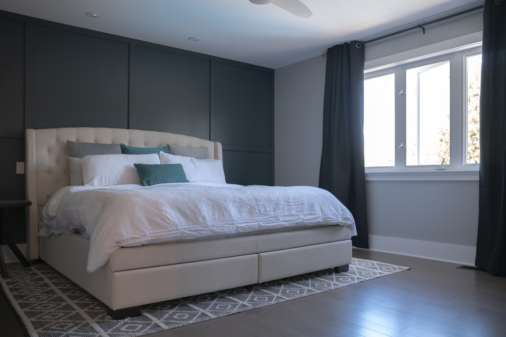 Contemporary master bedroom in Ottawa with grey walls, laminate floors, no fireplace, brown floor and decorative wall panelling.