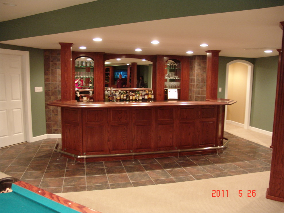 Design ideas for a large traditional single-wall seated home bar in St Louis with an undermount sink, recessed-panel cabinets, medium wood cabinets, granite benchtops and ceramic floors.