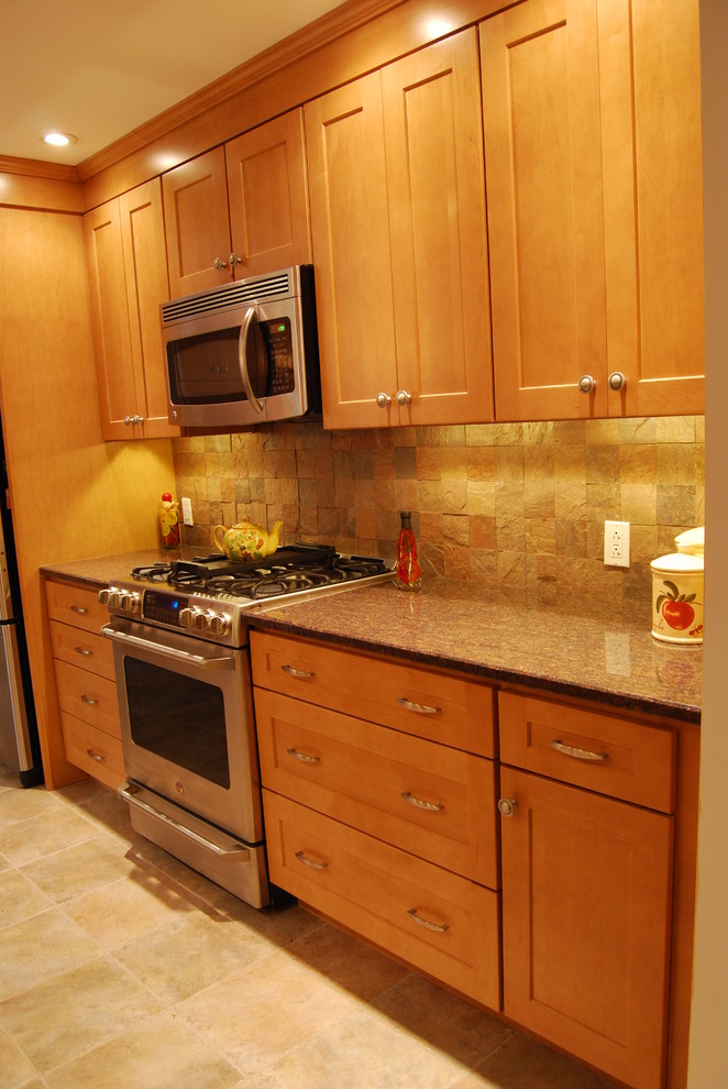Photo of a transitional galley eat-in kitchen in New York with flat-panel cabinets, light wood cabinets, beige splashback and stone tile splashback.