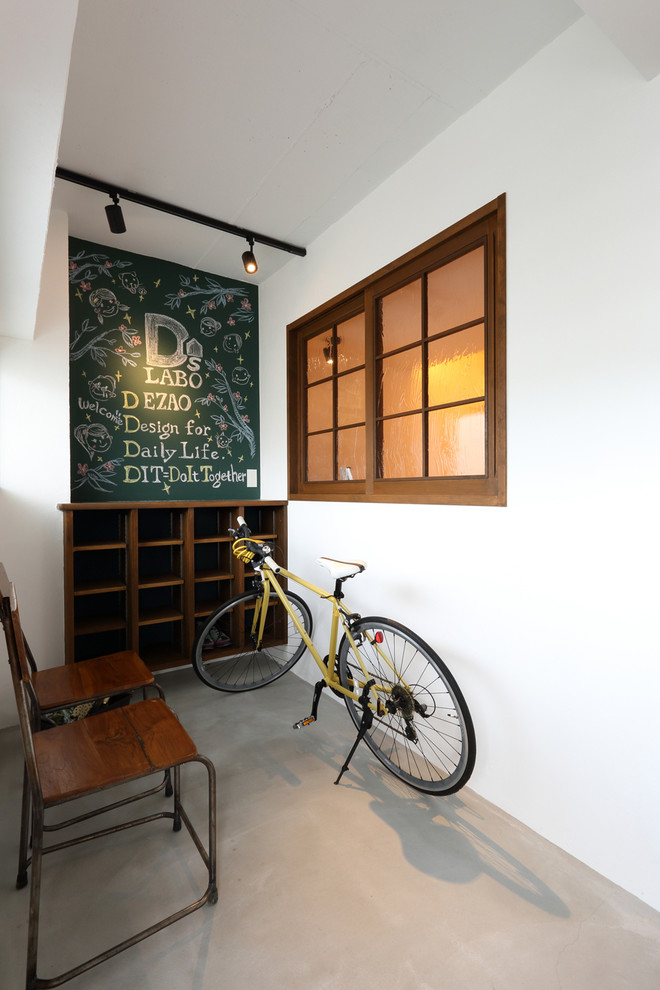 京都にあるアジアンスタイルのおしゃれな玄関 (白い壁、コンクリートの床) の写真